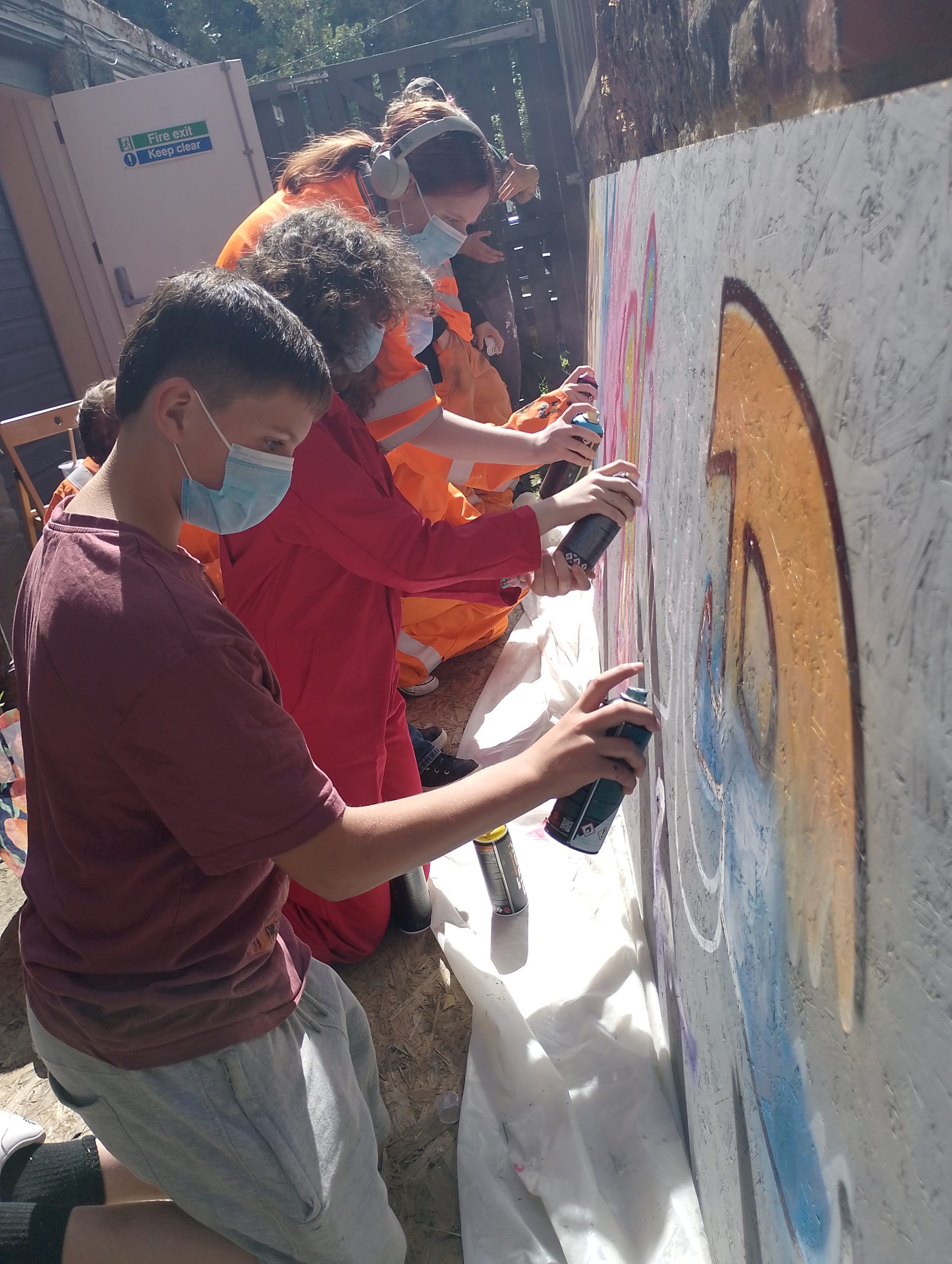 Young people working on a colourful painting