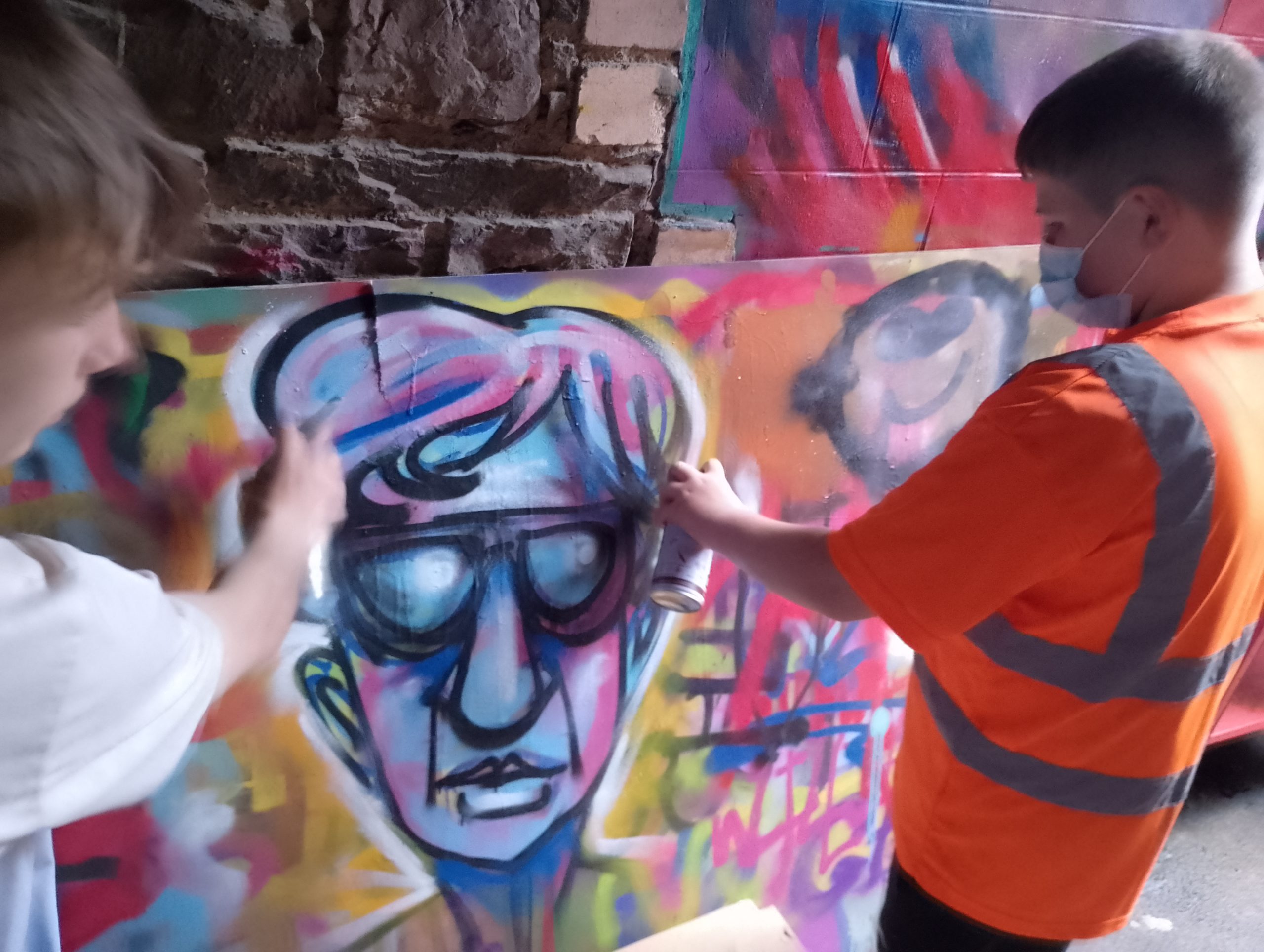 Young people creating a colourful mural