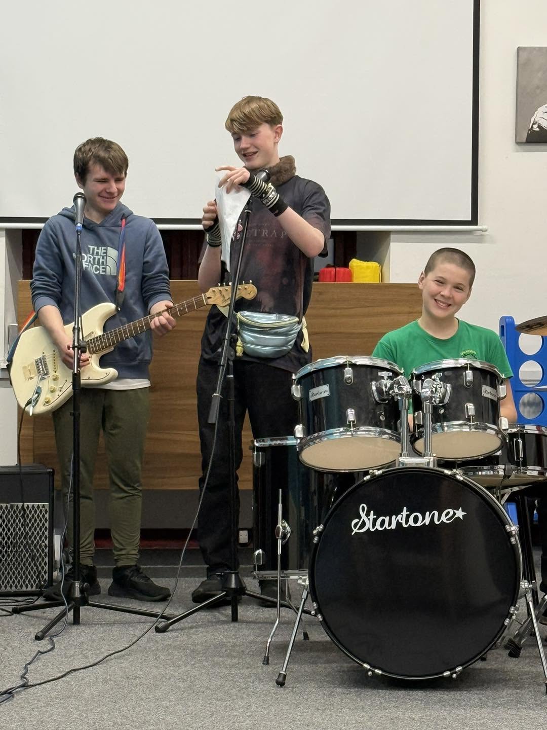 Young people playing guitars and drums together