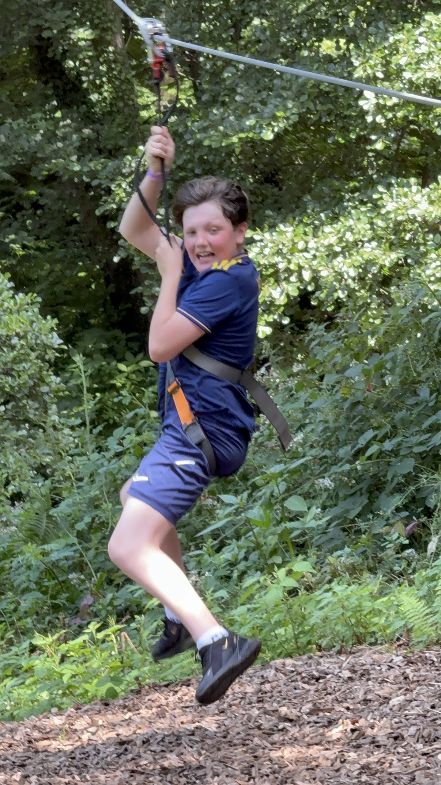A young person enjoying a woodland zip line