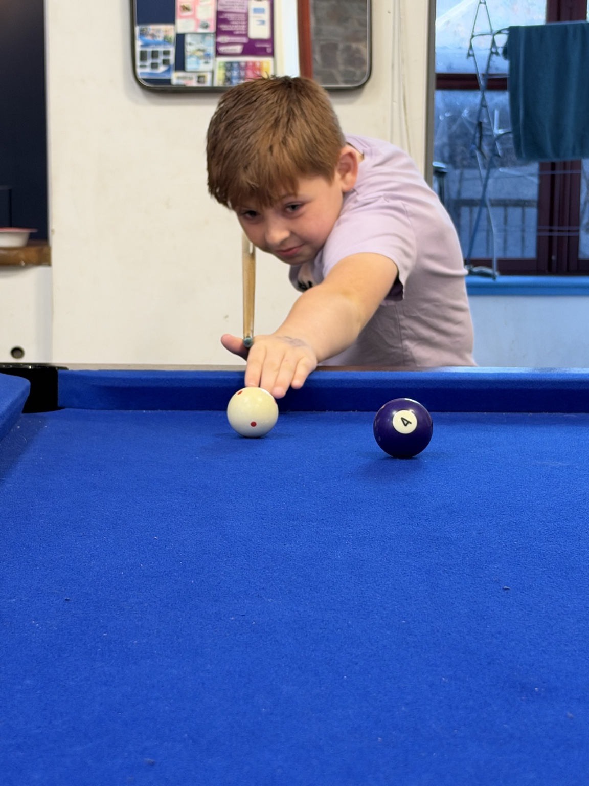 A young person playing pool at TD1 Youth Hub