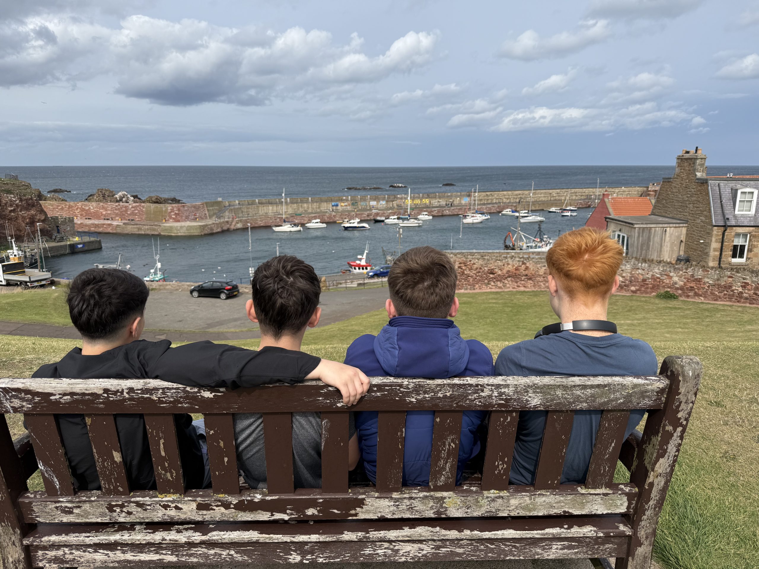 Young people looking out towards the sea together